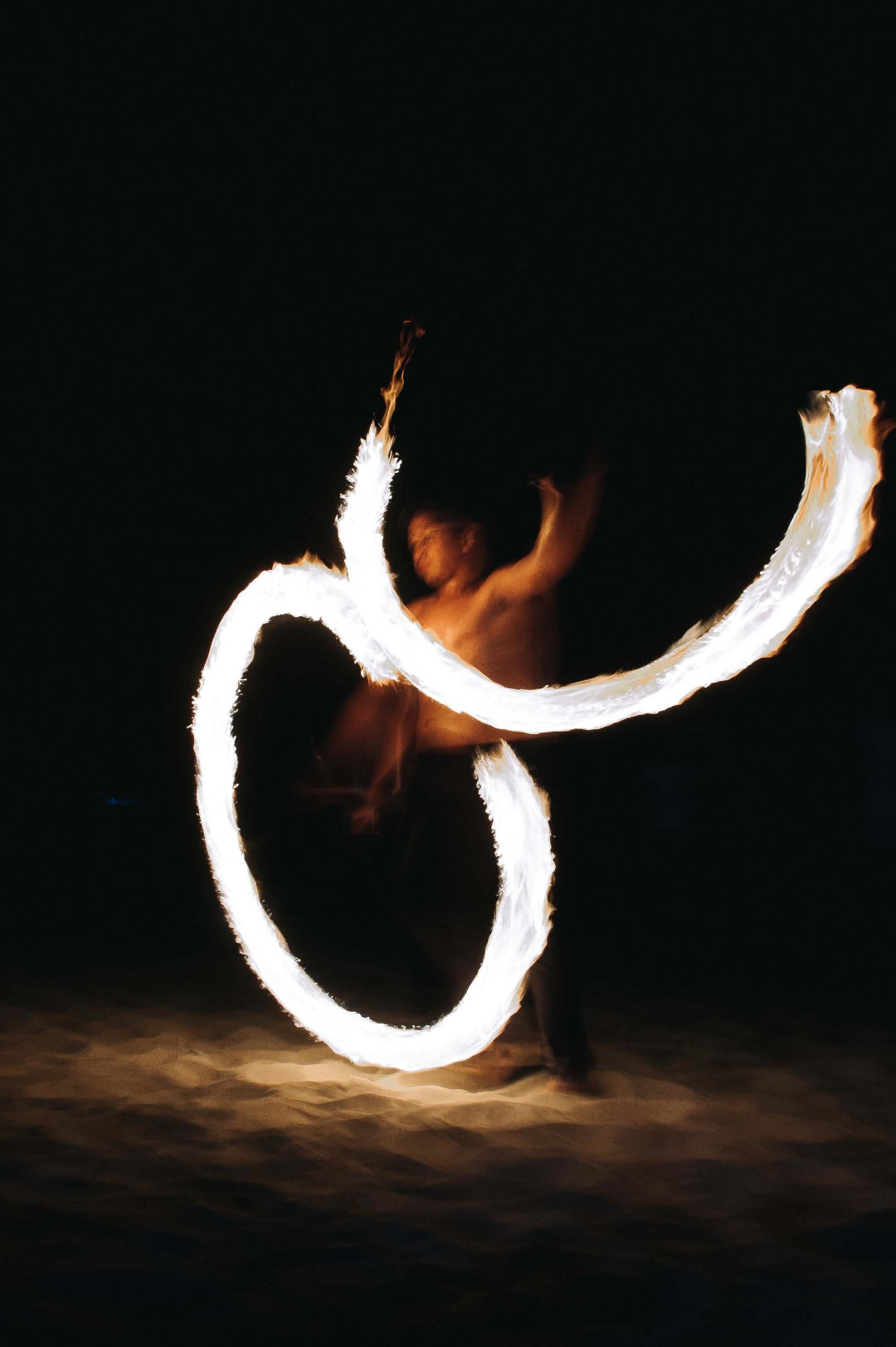 Fire dancer at night | Featured Image for the Storage Gas Hot Water Systems Page of JR Gas & Water. 